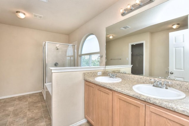 bathroom featuring visible vents, a stall shower, and a sink