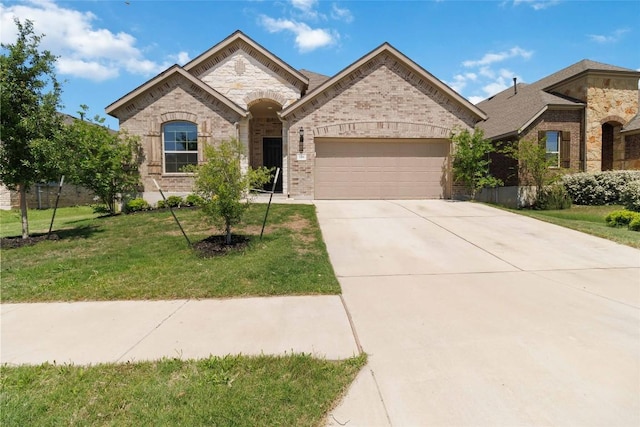 french provincial home featuring concrete driveway, stone siding, brick siding, a front yard, and a garage