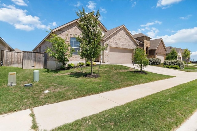 view of front facade with a garage, driveway, fence, a front yard, and brick siding
