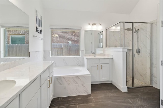 bathroom with a sink, a marble finish shower, a bath, marble finish floor, and two vanities