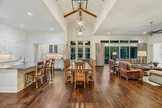 dining area featuring recessed lighting, a high ceiling, dark wood-style flooring, and ceiling fan with notable chandelier