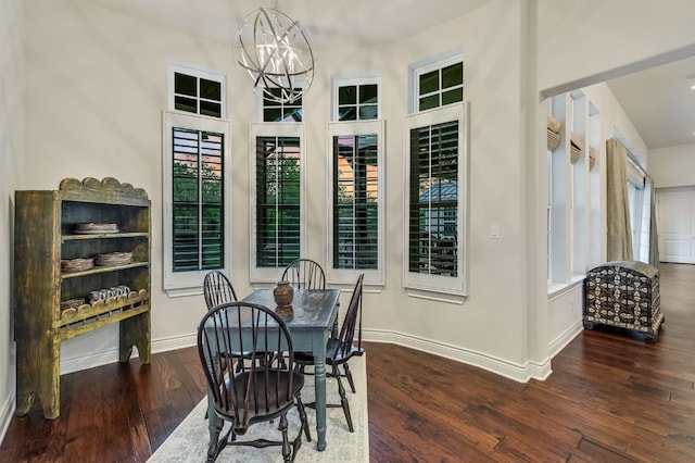 dining area featuring hardwood / wood-style flooring, baseboards, a chandelier, and plenty of natural light