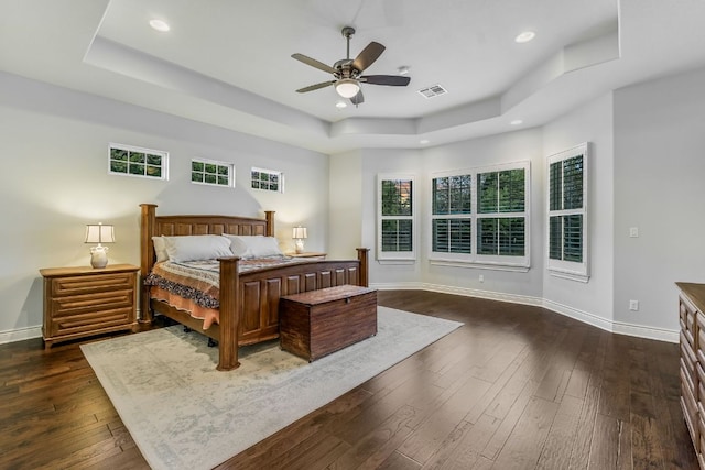 bedroom with dark wood-style floors, baseboards, visible vents, recessed lighting, and a raised ceiling