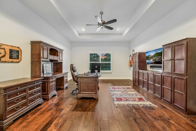 home office featuring recessed lighting, a raised ceiling, a ceiling fan, baseboards, and dark wood-style flooring