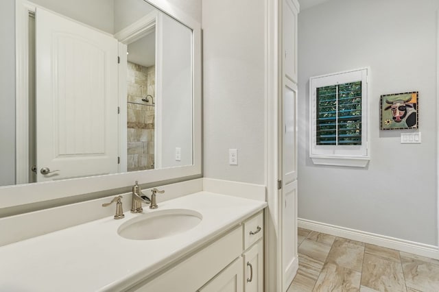 bathroom featuring baseboards, vanity, and tiled shower