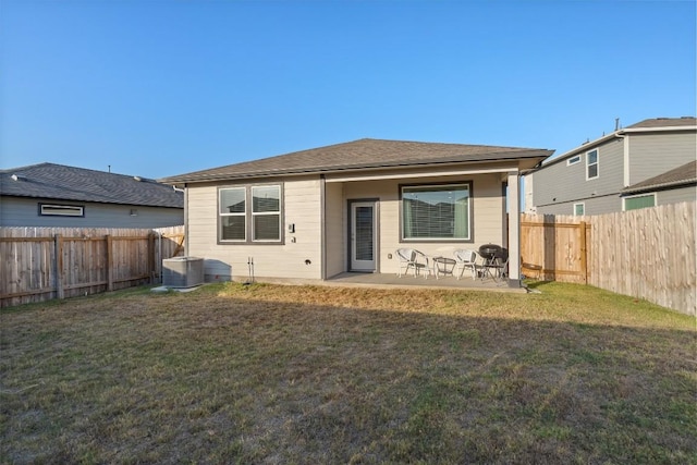 rear view of house featuring a yard, a patio, and a fenced backyard