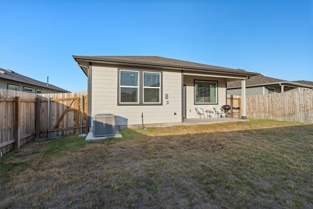 rear view of house featuring a lawn, a patio, a fenced backyard, and central AC unit
