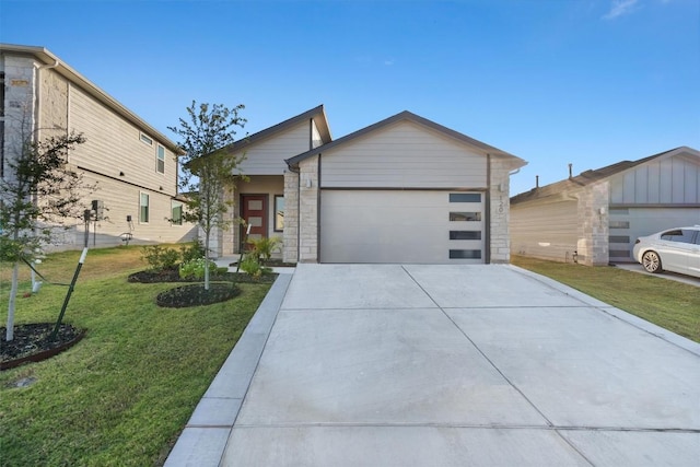 view of front facade featuring concrete driveway, an attached garage, stone siding, and a front yard