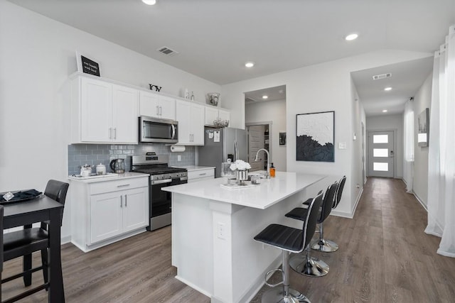 kitchen featuring dark wood-type flooring, light countertops, stainless steel appliances, and a sink