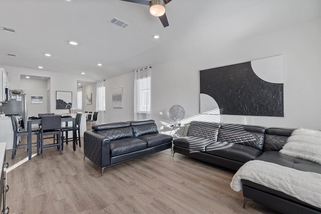 living room featuring recessed lighting, a ceiling fan, visible vents, and light wood-type flooring