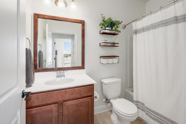 bathroom with vanity, toilet, baseboards, wood finished floors, and shower / bath combination with curtain