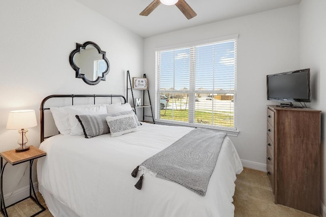 bedroom featuring ceiling fan, baseboards, carpet flooring, and multiple windows