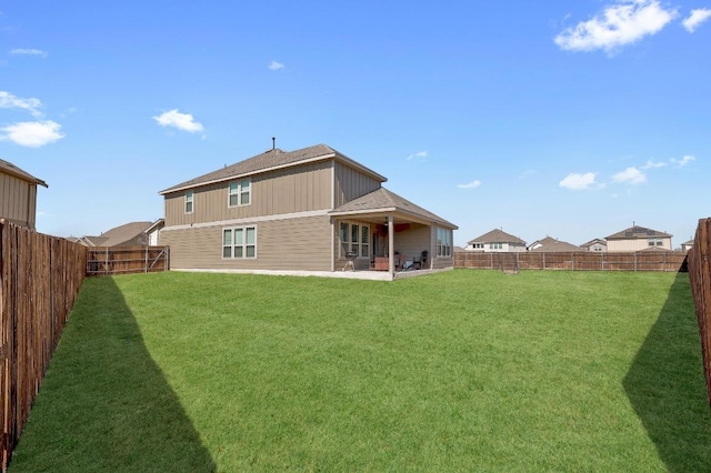 back of house featuring a fenced backyard, a patio area, and a lawn