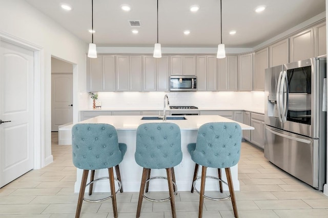 kitchen with decorative backsplash, stainless steel appliances, light countertops, and a sink