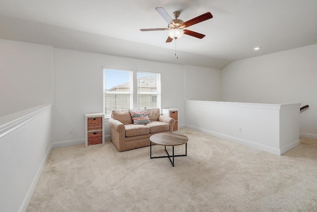 living room with baseboards, light colored carpet, and ceiling fan