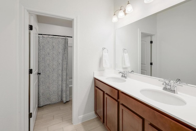 full bath with shower / tub combo, a sink, and double vanity