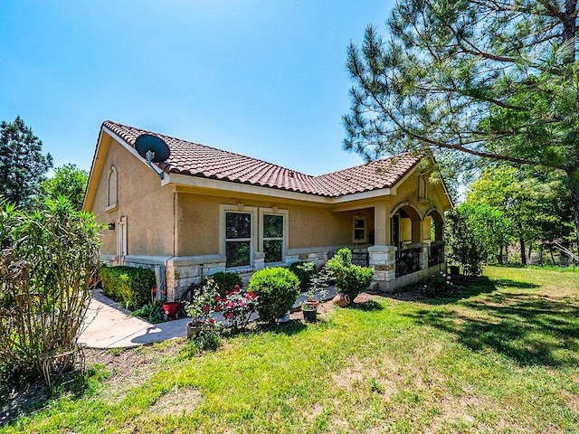 316 County Rd, Bastrop, TX 78602 - back of property with stucco siding, stone siding, a yard, and a tile roof