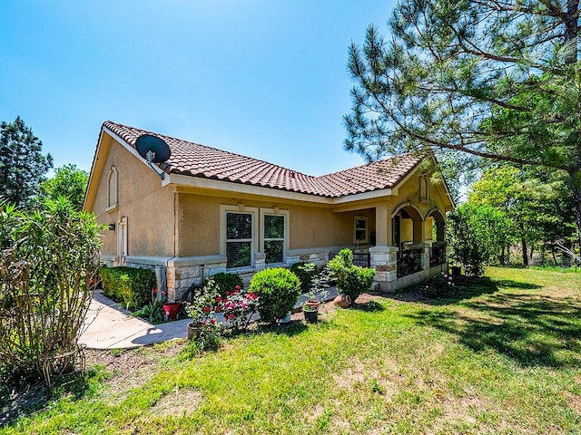 316 County Rd, Bastrop, TX 78602 - view of property exterior featuring stone siding, stucco siding, a yard, and a tiled roof