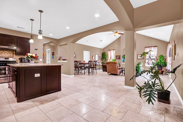 316 County Rd, Bastrop, TX 78602 - kitchen featuring stainless steel gas stove, under cabinet range hood, arched walkways, a ceiling fan, and dark brown cabinets