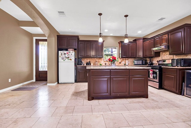 316 County Rd, Bastrop, TX 78602 - kitchen featuring freestanding refrigerator, gas range, under cabinet range hood, black microwave, and dark brown cabinets