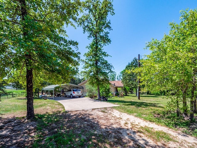 316 County Rd, Bastrop, TX 78602 - view of property hidden behind natural elements featuring a carport, concrete driveway, and a tiled roof