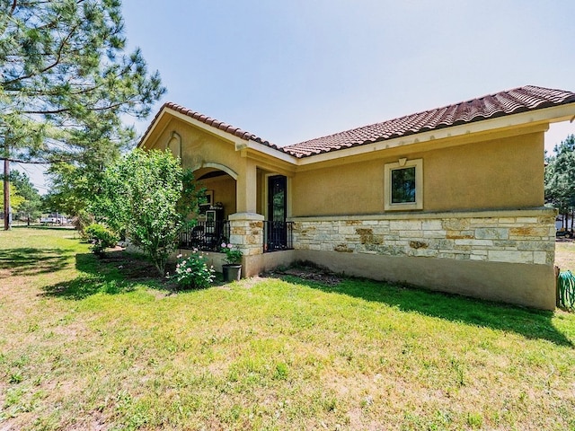 316 County Rd, Bastrop, TX 78602 - mediterranean / spanish house featuring stone siding, a front lawn, and stucco siding