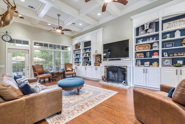living room featuring beamed ceiling, a ceiling fan, visible vents, and a healthy amount of sunlight