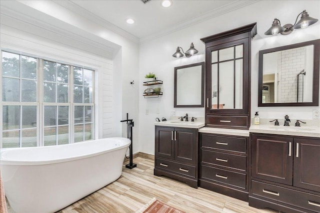 bathroom featuring a freestanding bath, a sink, and double vanity