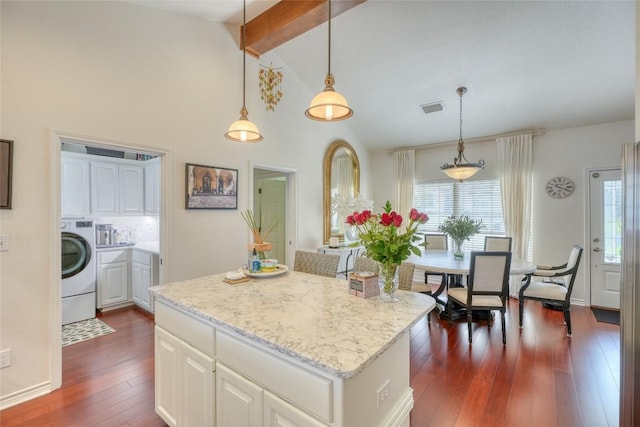 kitchen with light stone counters, white cabinets, dark wood finished floors, washer / clothes dryer, and visible vents