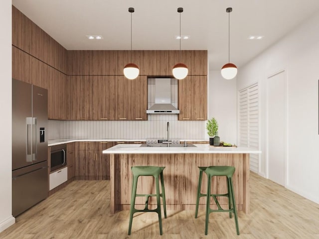 kitchen featuring brown cabinets, stainless steel appliances, wall chimney range hood, modern cabinets, and decorative backsplash