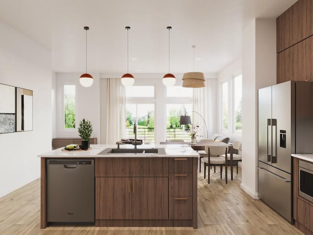 kitchen featuring light countertops, a sink, stainless steel appliances, and modern cabinets