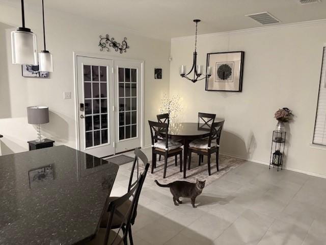 dining area featuring visible vents, an inviting chandelier, and ornamental molding