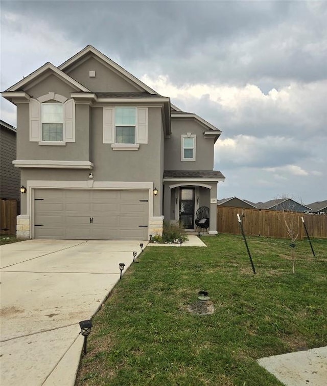 traditional home with fence, concrete driveway, an attached garage, stucco siding, and a front yard