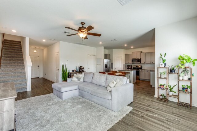 living area featuring recessed lighting, stairway, wood finished floors, visible vents, and a ceiling fan