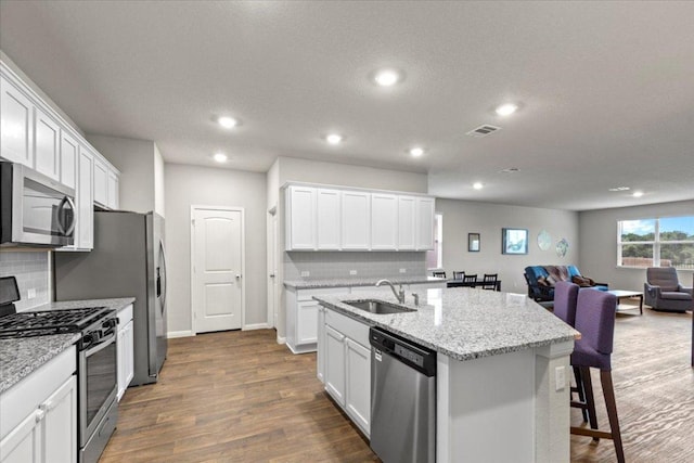 609 Bluffview Dr, Bastrop, TX 78602 - kitchen featuring appliances with stainless steel finishes, a sink, open floor plan, decorative backsplash, and recessed lighting