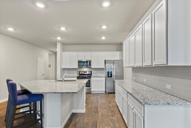 609 Bluffview Dr, Bastrop, TX 78602 - kitchen featuring appliances with stainless steel finishes, dark wood-style floors, tasteful backsplash, white cabinets, and recessed lighting