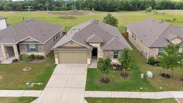 609 Bluffview Dr, Bastrop, TX 78602 - view of front of home featuring concrete driveway, an attached garage, brick siding, a front yard, and roof with shingles