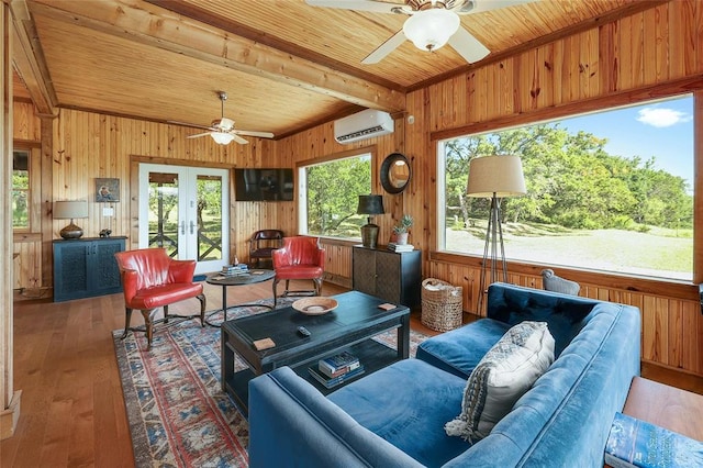 living area with lofted ceiling with beams, wooden walls, a wall mounted air conditioner, ceiling fan, and wooden ceiling