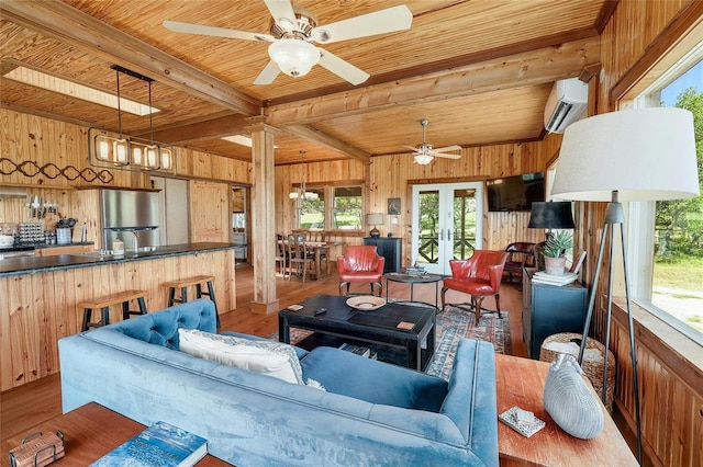 living area featuring wooden walls, wood finished floors, an AC wall unit, a ceiling fan, and wood ceiling