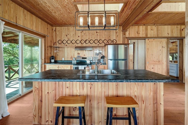 kitchen featuring dark countertops, wooden walls, a wealth of natural light, stainless steel appliances, and wooden ceiling