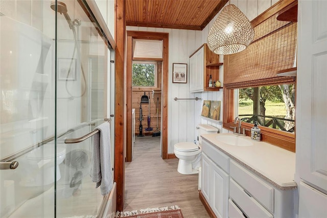 full bath with a stall shower, wood finished floors, wood ceiling, wooden walls, and vanity