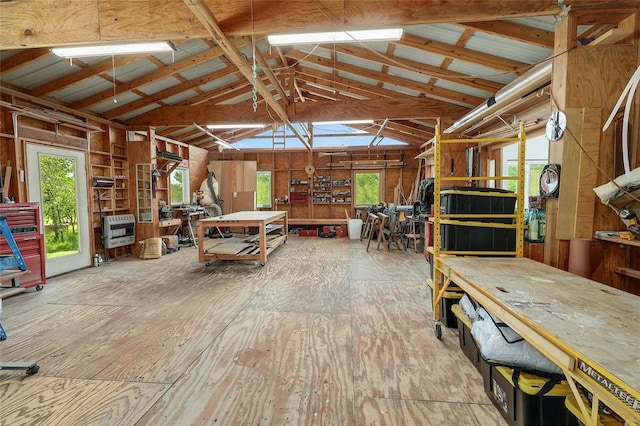 miscellaneous room with heating unit, vaulted ceiling, and a workshop area