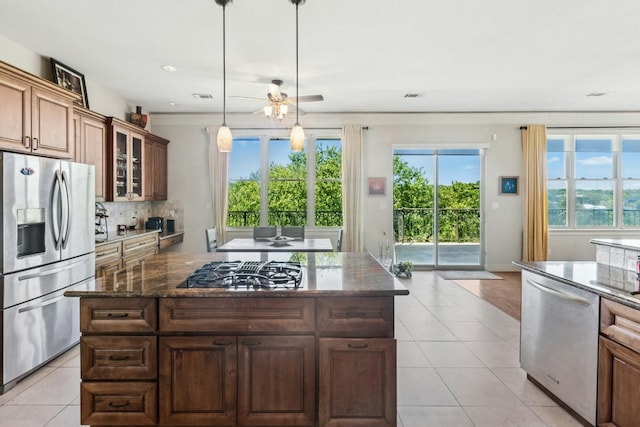 1204 Ogden Dr, Austin, TX 78733 - kitchen with stainless steel appliances, healthy amount of natural light, light tile patterned floors, a ceiling fan, and recessed lighting