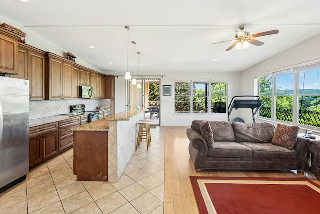 1204 Ogden Dr, Austin, TX 78733 - kitchen featuring stainless steel appliances, open floor plan, a ceiling fan, decorative backsplash, and light stone counters