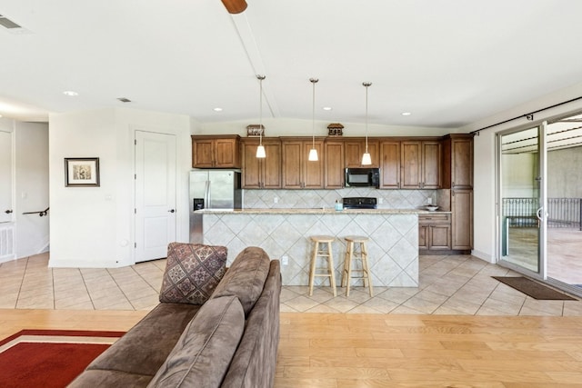 1204 Ogden Dr, Austin, TX 78733 - kitchen with black appliances, backsplash, a center island, light tile patterned floors, and recessed lighting