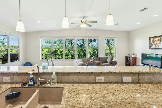 1204 Ogden Dr, Austin, TX 78733 - kitchen featuring plenty of natural light, light stone countertops, ceiling fan, lofted ceiling, and hanging light fixtures
