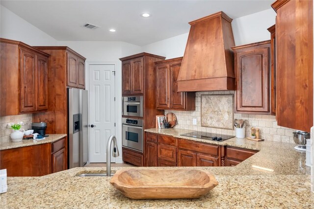 15 Chandon Ln, Lakeway, TX 78734 - kitchen featuring stainless steel fridge with ice dispenser, premium range hood, black electric stovetop, light stone counters, and backsplash