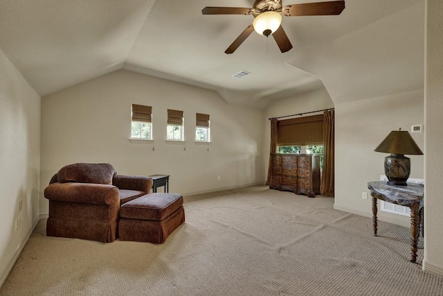 sitting room with vaulted ceiling, visible vents, light colored carpet, and a wealth of natural light