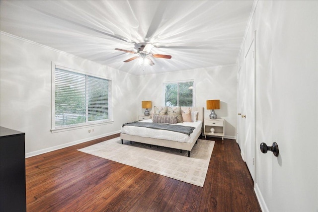 bedroom with wood finished floors, crown molding, baseboards, and a ceiling fan
