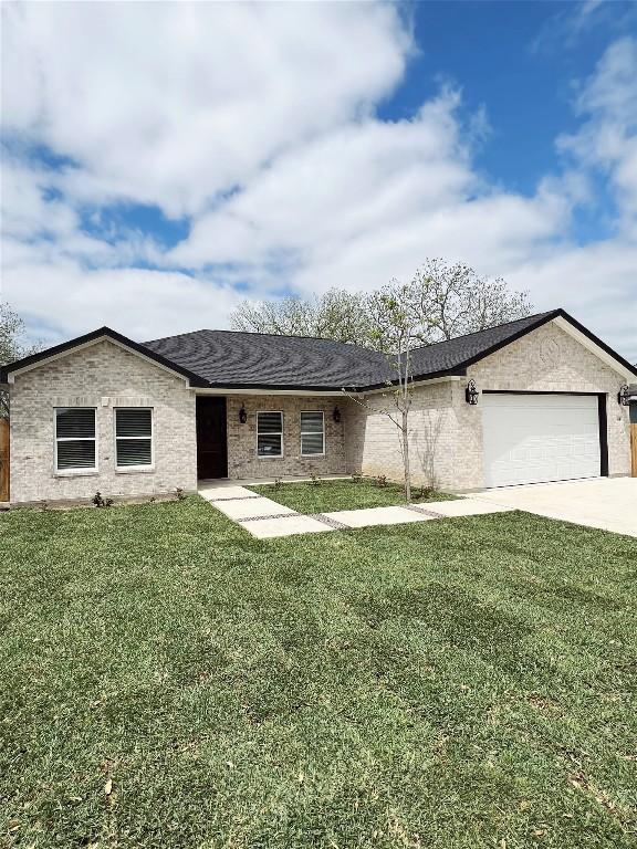 ranch-style home featuring a garage, driveway, and a front yard